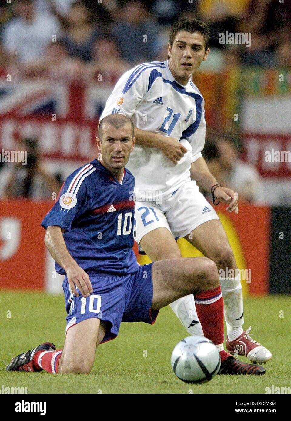 (dpa) - French midfielder and team captain Zinedine Zidane (front) is attacked by his Greek counterpart Konstantinos Katsouranis during the Soccer Euro 2004 quarter final opposing France and Greece in Lisbon, Portugal, 25 June 2004. With a sensational 1-0 victory Greece eliminates title defender France. +++NO MOBILE PHONE APPLICATIONS +++ Stock Photo