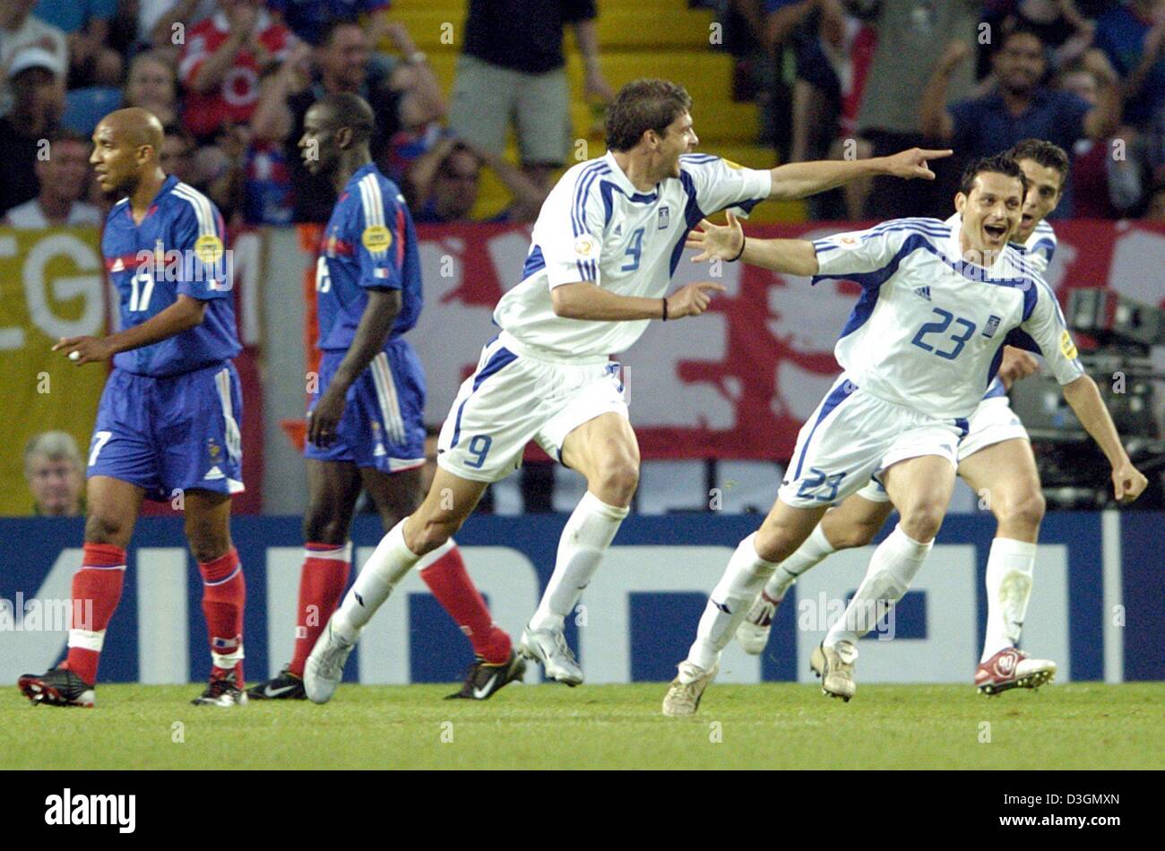 (dpa) - Greek forward Angelos Charisteas (C) cheers with his teammates Vassilos Lakis (2nd from L) and Konstantinos Katsouranis (R) after scoring during the Soccer Euro 2004 quarter final opposing France and Greece in Lisbon, Portugal, 25 June 2004. French players Liliam Thuram (2nd from R) and Olivier Dacourt look defeated. With a sensational 1-0 victory Greece eliminates title de Stock Photo