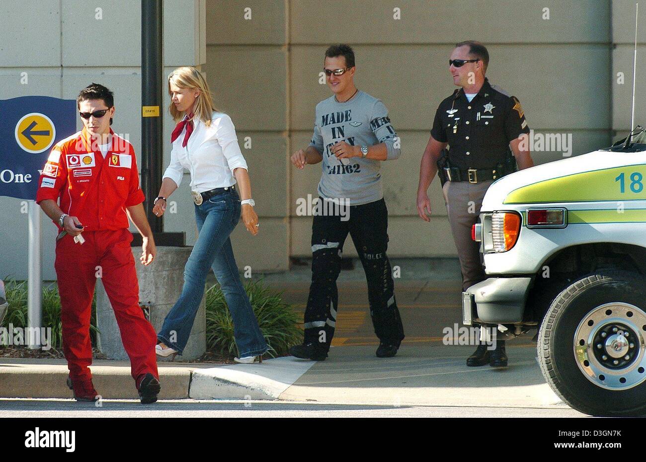 (dpa) - German formula one pilot Michael Schumacher (2nd from R) of Ferrari and his wife Corinna (2nd from L), a Ferrari driver (L) and a sherriff leave the building after visiting brother Ralf Schumacher at the Methodist hospital in Indianapolis, USA, 20 June 2004. Ralf Schumach ran with top speed into a barrier along the racetrack in an accident in the tenth lap during the US Gra Stock Photo