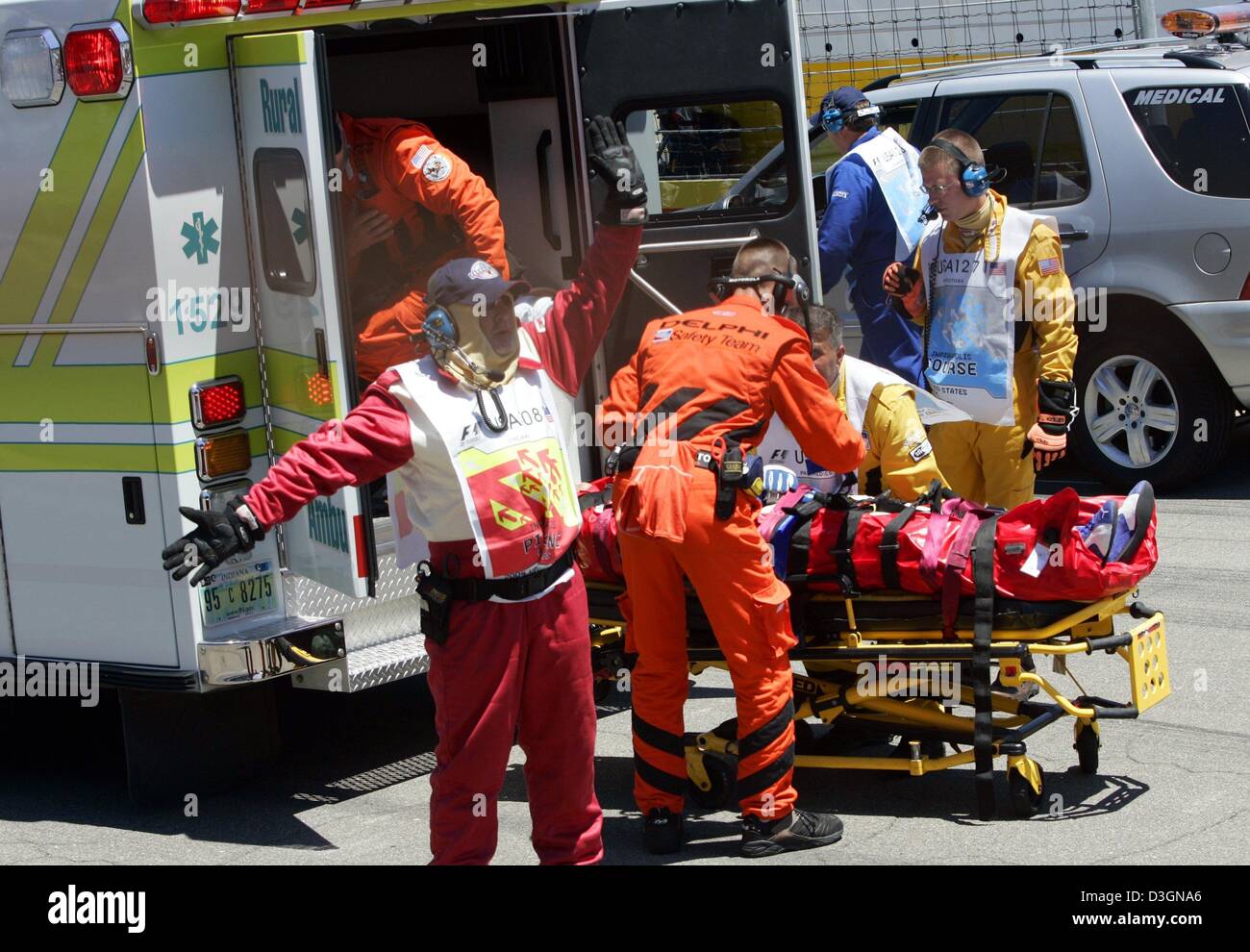 (dpa) - Paramedics and members of the safety team take German formula one pilot Ralf Schumacher of BMW-Williams lying on a stretcher to an ambulance van after his accident during the US Grand Prix on the racetrack in Indianapolis, USA, 20 June 2004. Ralf Schumach ran with top speed of around 300 kilometres per hour into a barrier along the racetrack in the tenth lap of the race. Stock Photo