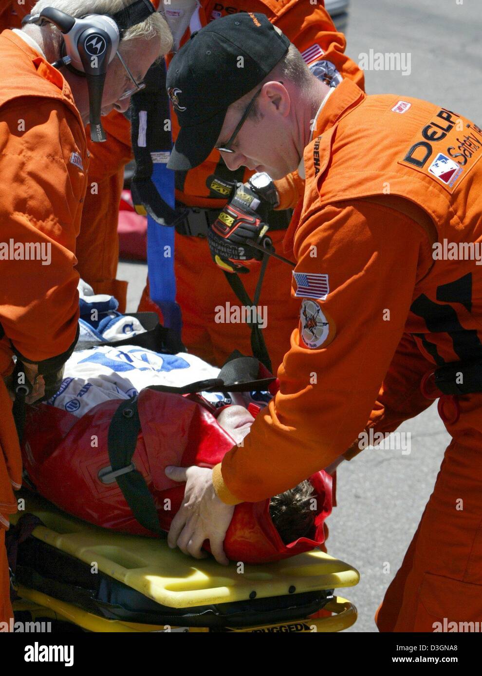 (dpa) - Paramedics and members of the safety team position German formula one pilot Ralf Schumacher of BMW-Williams on a stretcher after his accident during the US Grand Prix on the racetrack in Indianapolis, USA, 20 June 2004. Ralf Schumach ran with top speed of around 300 kilometres per hour into a barrier along the racetrack in the tenth lap of the race. Stock Photo