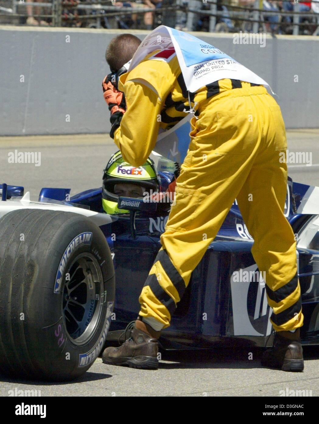 (dpa) - A member of the safety team speaks to German formula one pilot Ralf Schumacher of BMW-Williams as he sits in his racing car waiting for the arrival of the paramedics after his accident during the US Grand Prix on the racetrack in Indianapolis, USA, 20 June 2004. Ralf Schumach ran with a top speed of around 300 kilometres per hour into a barrier along the racetrack in the te Stock Photo