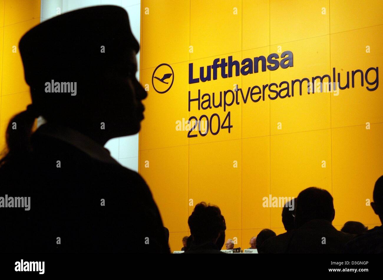 (dpa) - A stewardess of German airline Lufthansa listens during the company's general meeting in Cologne, Germany, 16 June 2004. Lufthansa has a positive outlook for the current year but also warns of more taxes on airline travel in Germany. Passenger numbers, flight occupancy and average profits had increased significantly said Lufthansa chairman Wolfgang Mayrhuber and announced a Stock Photo