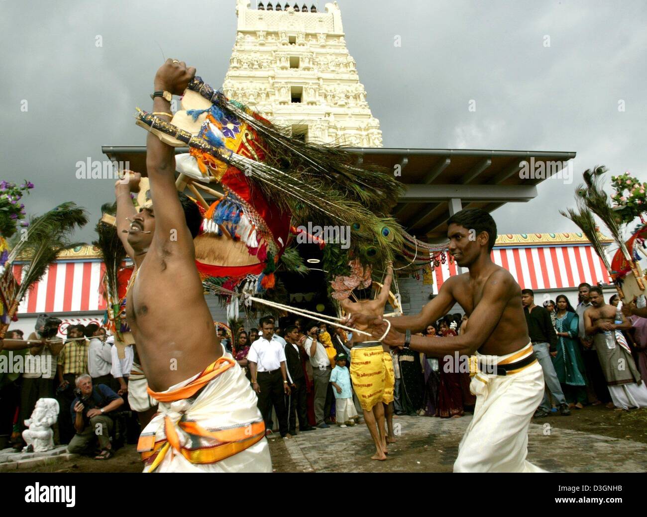 (dpa) - Devoted Hindus with iron hooks drilled into the skin on their backs dance during a traditional procession of about 15,000 believers near a temple in Hamm, Germany, 6  June 2004. The annual procession at the Sri Kamadchi Ampal Temple is one of the largest religious events for Tamil Hindus in Europe. Stock Photo