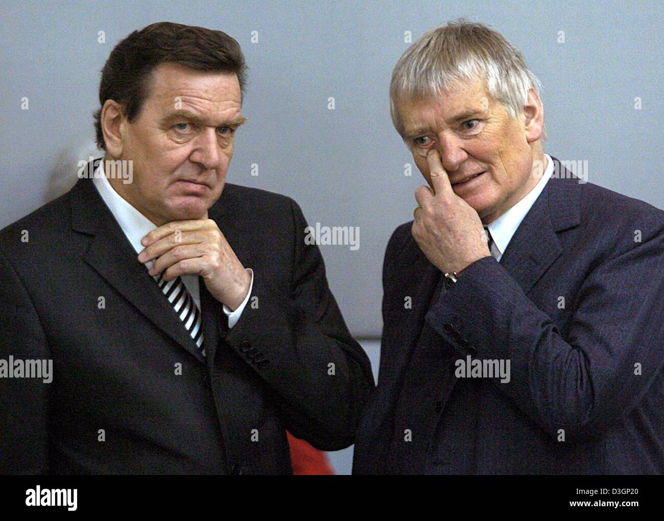 (dpa) - German Chancellor Gerhard Schroeder (L) talks to Interior Minister Otto Schily (R) in the Bundestag, the lower house of parliament, in Berlin, on Thursday, 11 March 2004. Germany's parliament Thursday approved a pension reform which will cut state pensions in the coming years despite unease among some members of the Social Democratic Party. The reform aims to keep German st Stock Photo