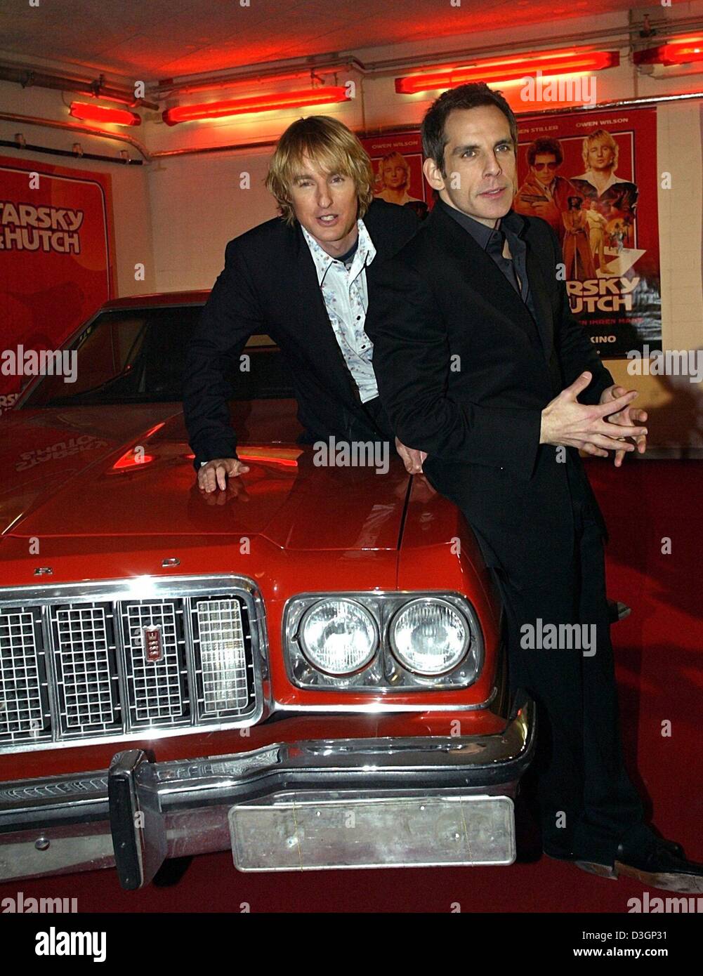 (dpa) - US actors Owen Wilson and Ben Stiller (R) pose on the hood of their film car, a glaring red Ford Gran Torino, at the premiere of their film 'Starsky & Hutch' in Munich, 9 March 2004. Owen and Stiller play the cop duo Ken Hutchinson and David Starsky in the remake of the legendary 1970's television series. The red car with a white rallye stripe at the sides was the trademark Stock Photo