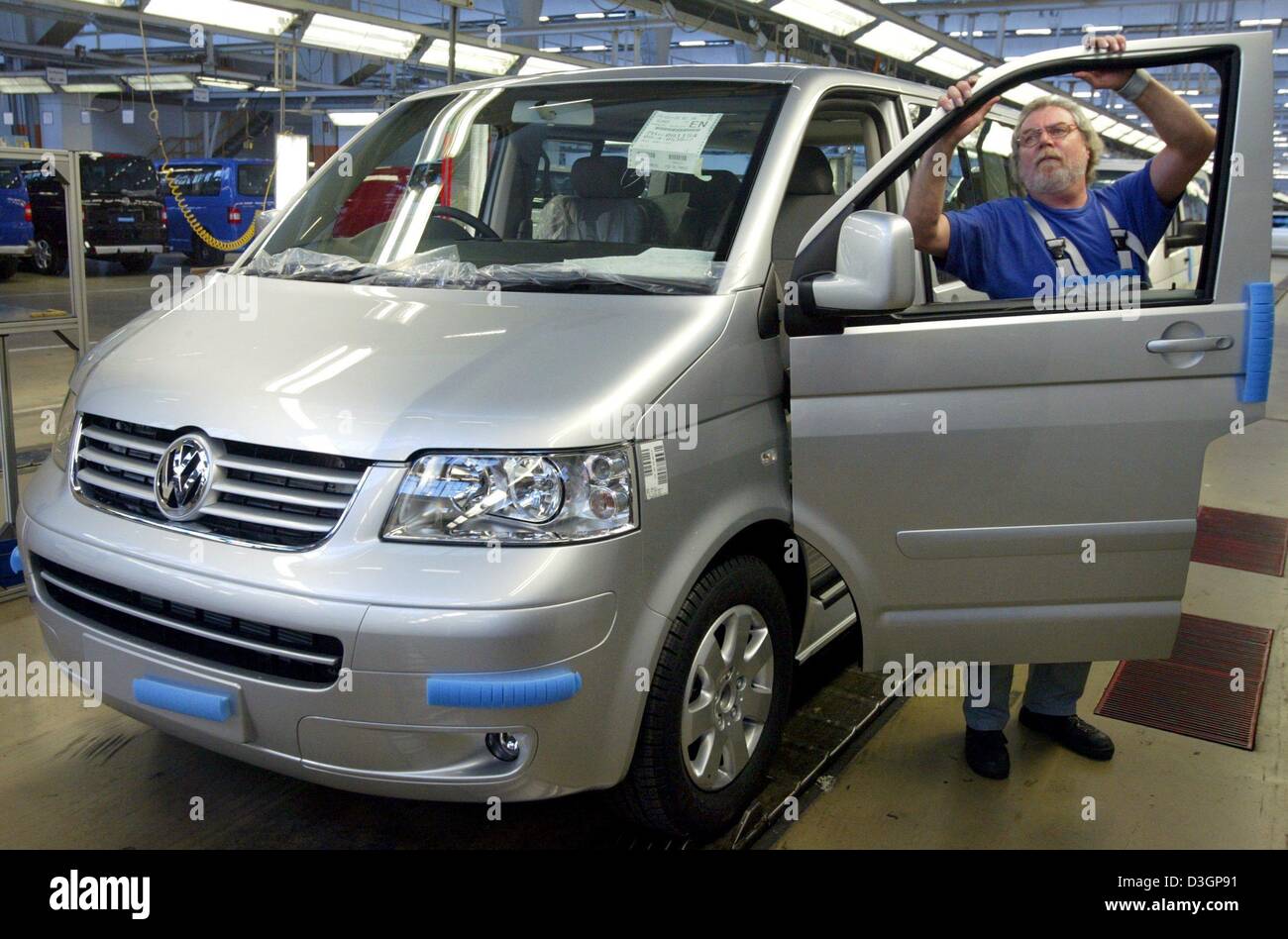 dpa) - A worker checks a finished VW T5 Multivan destined for the