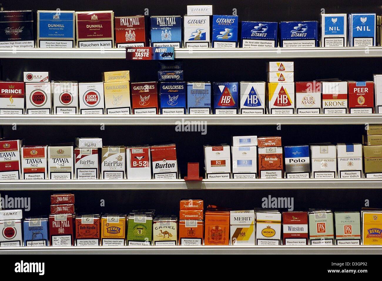 (dpa) - A view of a shelf of cigarette packs in a tobacco shop in Regensburg, Germany, 4 March 2004. The price of one pack with 19 cigarettes was raised 40 cents on 1 March 2004 in Germany. One pack now costs between 3.40 to 3.60 euros. The higher price is due to an increase of 1.2 cents of tax on each cigarette. The tax will contribute to the budget of the public healthcare insura Stock Photo