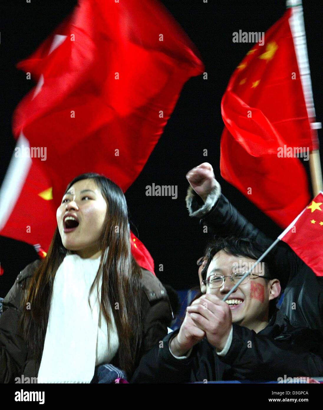 (dpa) Chinese fans cheer for their team during the ladies soccer match between Germany and China on Thursday, 4 March, 2004 in Fuerth, southeastern Germany. The Chinese team beat Germany 1:0. Stock Photo