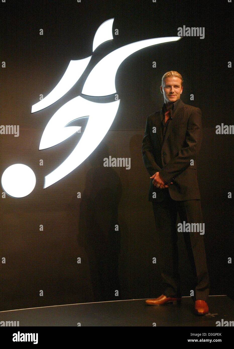 dpa) English soccer star David Beckham poses for the photographers in front  of his new logo at the Adidas headquarters in Herzogenaurach on Wednesday,  3 March, 2004. The design of the logo