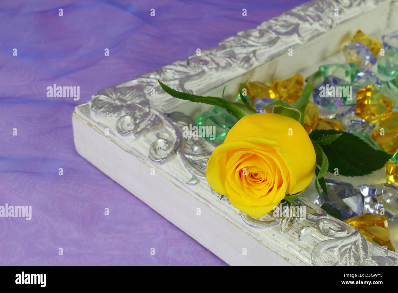 Vintage tray with yellow rose and crystals on purple background Stock Photo