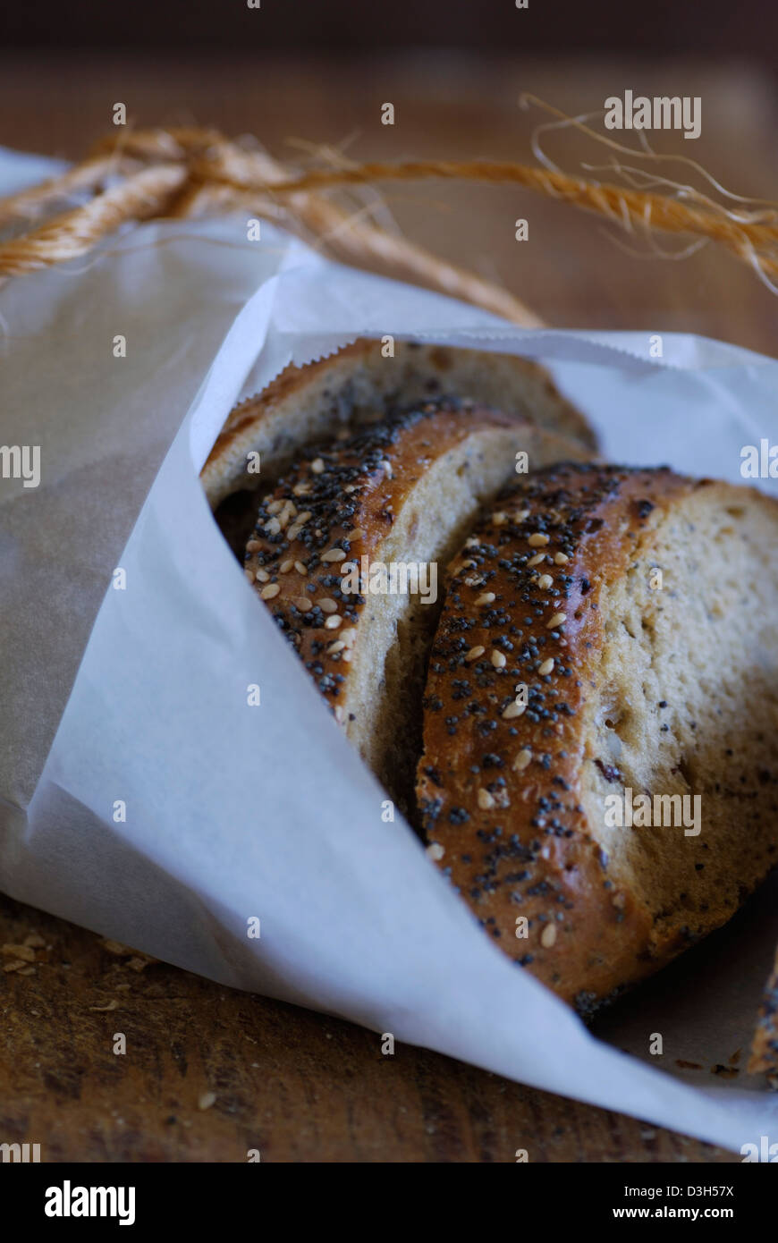Artisan Bread sliced and wrapped in white parchment paper with poppy