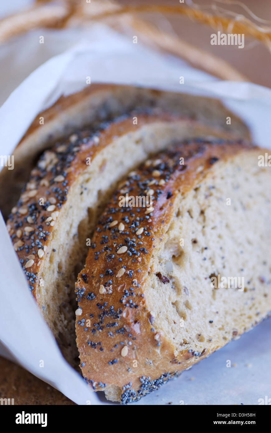 Artisan Bread sliced and wrapped in white parchment paper with poppy