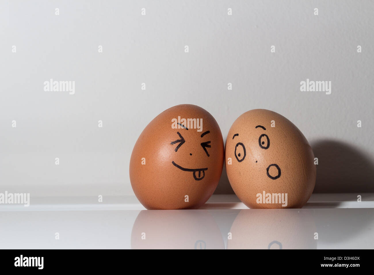 free range hens eggs in a fridge tray with funny faces drawn on them. Stock Photo