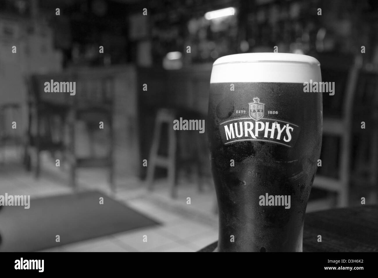 A pint of Murphy's Irish Stout rests on a table in a pub at Union Hall, West County Cork, Republic of Ireland. Stock Photo