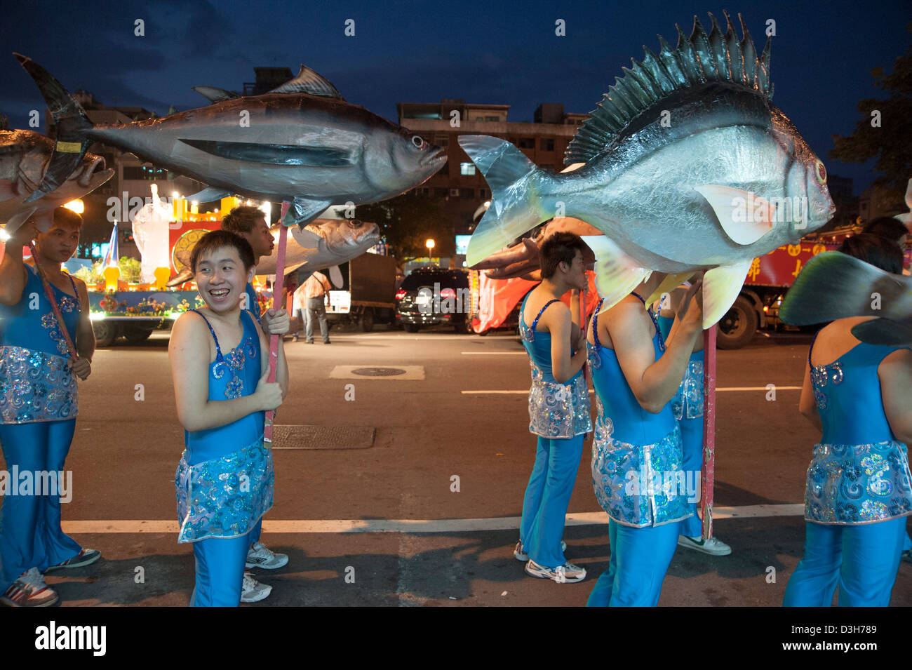 Boys carrying oversize seafood during a parade in Keelung, Taiwan Stock Photo