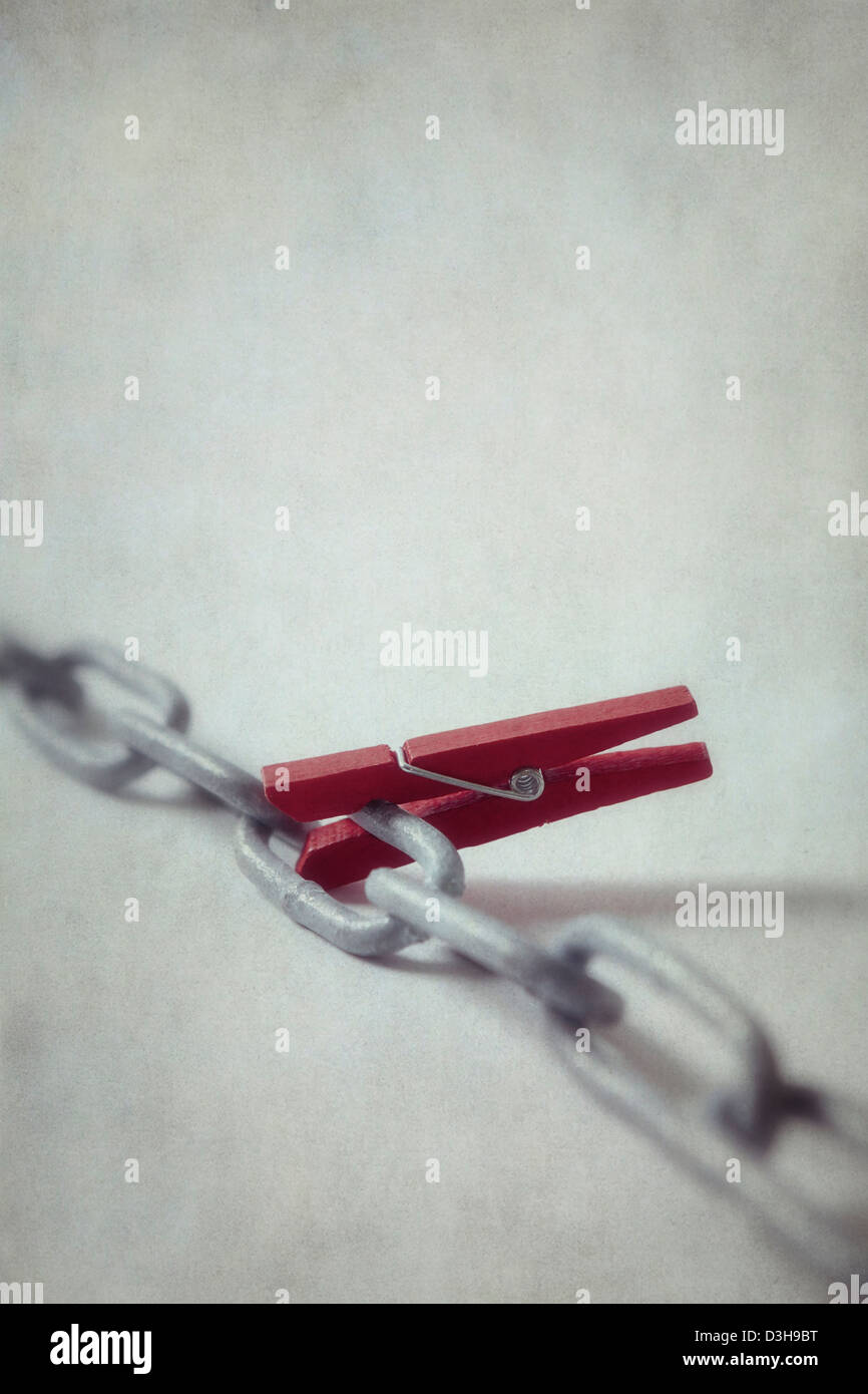 a red clothes-peg on a chain Stock Photo