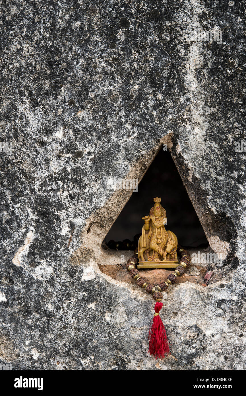 Lord Krishna statue and Indian Rudraksha / Japa Mala prayer beads in a temple wall. Andhra Pradesh, India Stock Photo