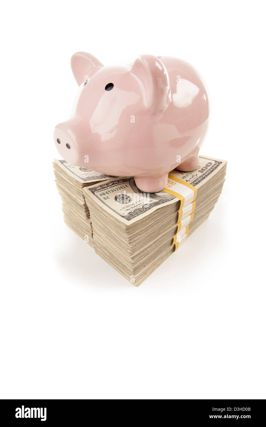 Pink Piggy Bank Standing on Stacks of Hundreds of Dollars Isolated on a White Background. Stock Photo