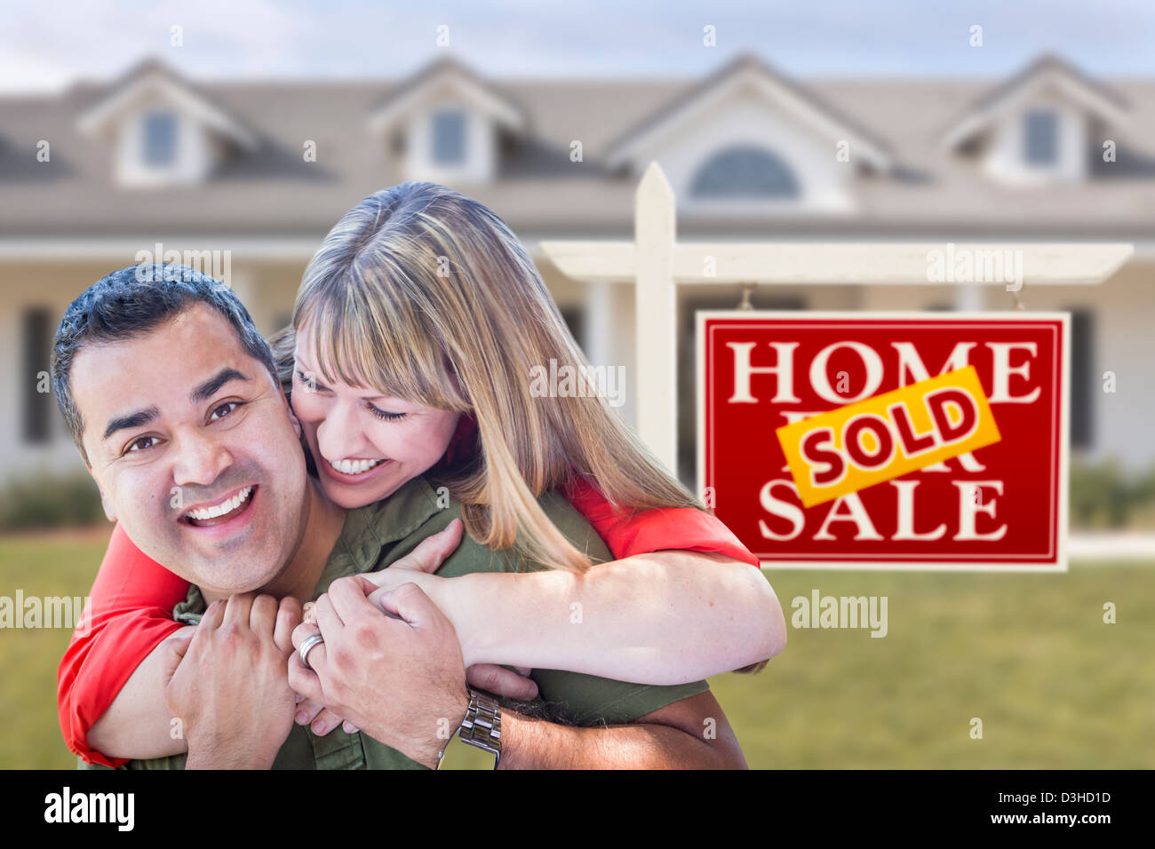 Happy Mixed Race Couple in Front of Sold Real Estate Sign and New House ...