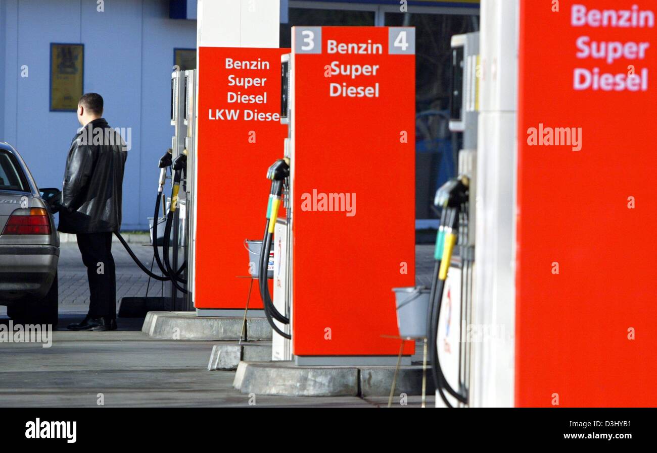 (dpa) - A man uses a petrol pump and puts petrol in his car at a 'Total' petrol station in Frankfurt Main, Germany, 18 December 2004. Stock Photo