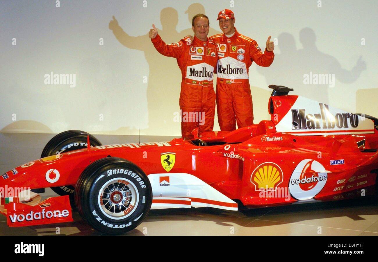 (dpa) - German formula one pilot Michael Schumacher and Brazilian pilot Rubens Barrichello (L)  gesture the thumbs-up sign after the new Ferrari formula one car for the season 2004 was unveiled in Maranello, Italy, 26 January 2004. The formula one season kicks off on 7 March in Australia. Stock Photo