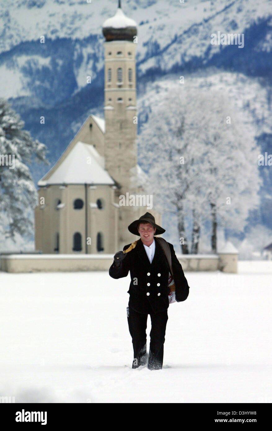 (dpa) - Markus Neubert, a wandering carpenter apprentice dressed in his traditional clothing, smiles as he trudges through the snow covered landscape in Schwangau, Germany, 26 January 2004. Neubert wandering on the traditional tour for apprentices for the past three months. Traditional apprentices have to wander for a period of three years and one day through Germany and are not al Stock Photo