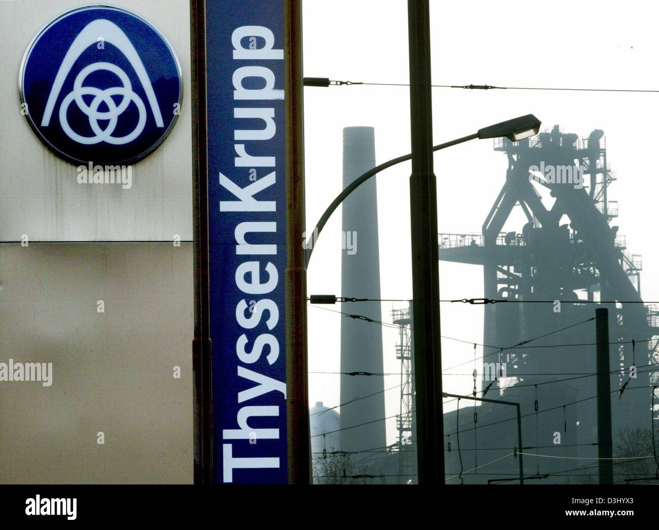 (dpa files) - The corporate logo of the ThyssenKrupp steelworks is seen in front of a furnace in Duisburg-Bruckhausen, Germany, 3 December 2003. On 23 January 2004 ThyssenKrupp affirmed their aim to achieve a gross result of close to a billion euros in the current 2003/2004 business year. The company also announced the key data for the first quarter of the current business year. Th Stock Photo