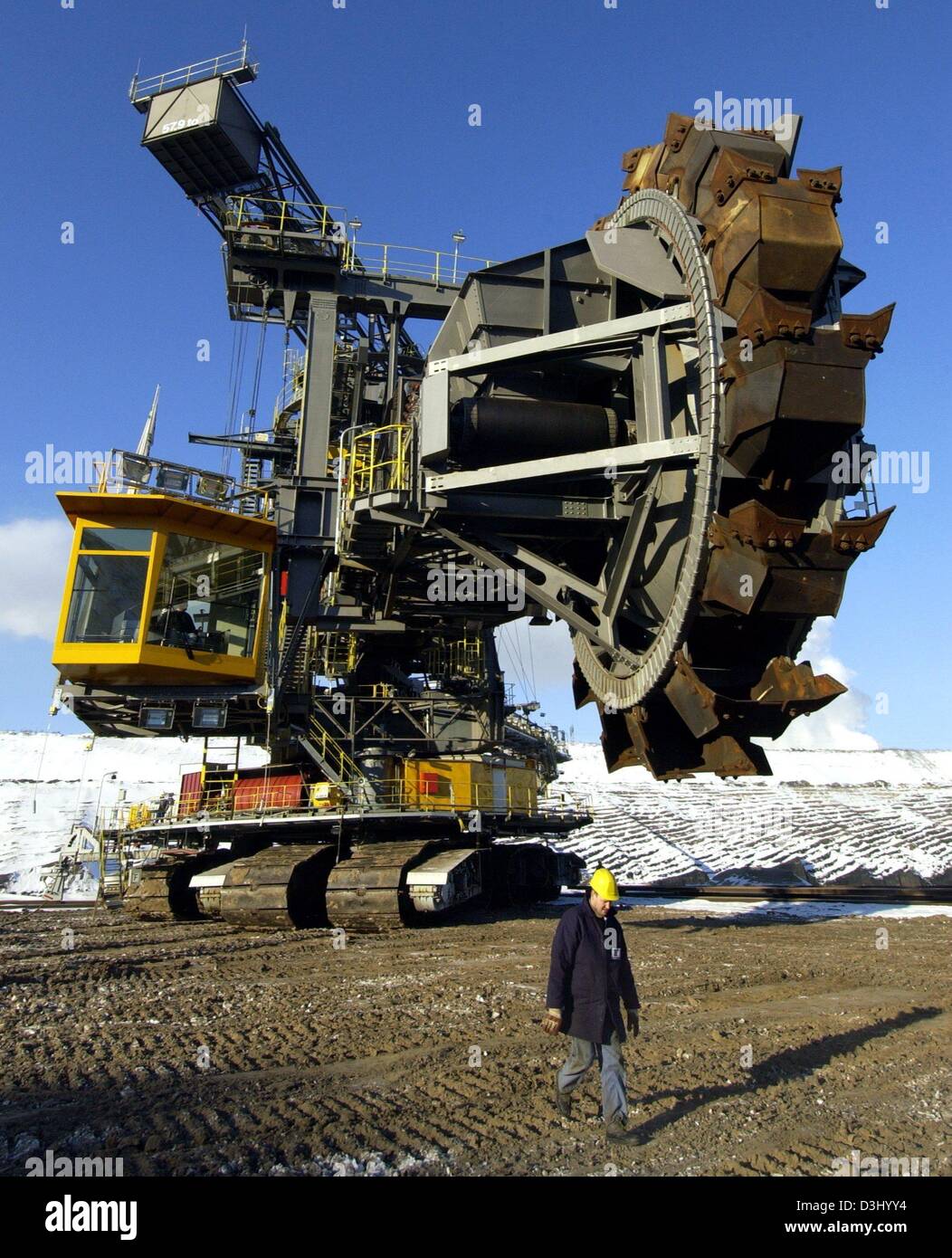 (dpa) - A giant bucket-wheel excavator of Vattenfall Europe Mining group (formerly LAUBAG) drives across the opencast pit in Jaenschwalde, eastern Germany, 22 January 2004. The excavator is moved 25 kilometres from a pit in Cottbus to the brown coal pit in Jaenschwalde. The travelling speed of the 1645 ton colossus is six metres per minute, and it will arrive at its final position  Stock Photo