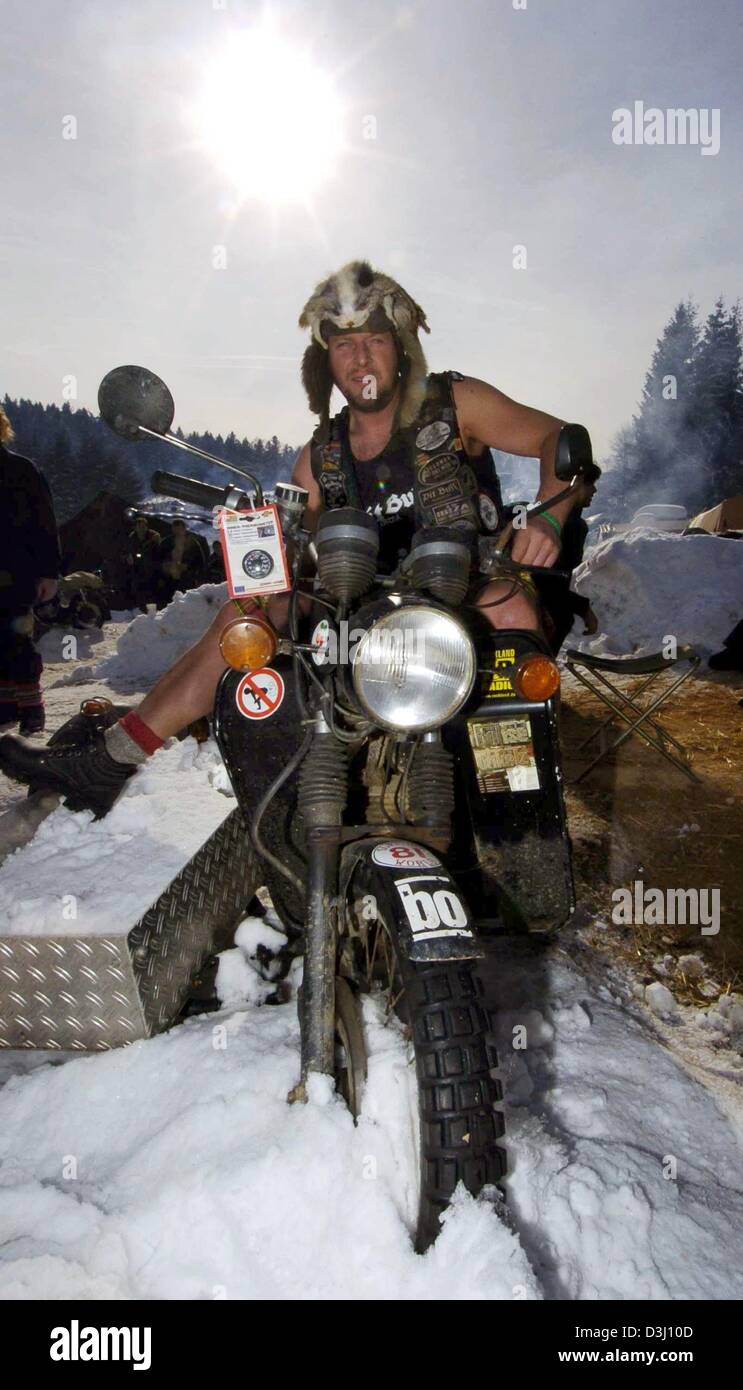 (dpa) - In bright sunshine a biker in shorts sits on his engine during a biker meeting in Thurmansbang, southern Germany, 31 January 2004. Stock Photo