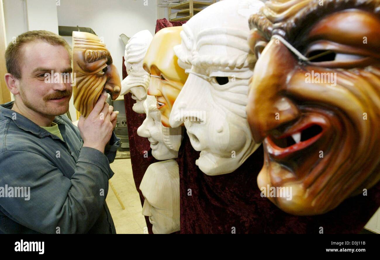 (dpa) - Carver Bernhard Ehmer poses in front of a shelf of his handmade wooden carnival masks in his workshop in Herxheim, Germany, 2 February 2004. The wooden masks are a tradition of the Alemannic carnival in southwestern Germany. Stock Photo