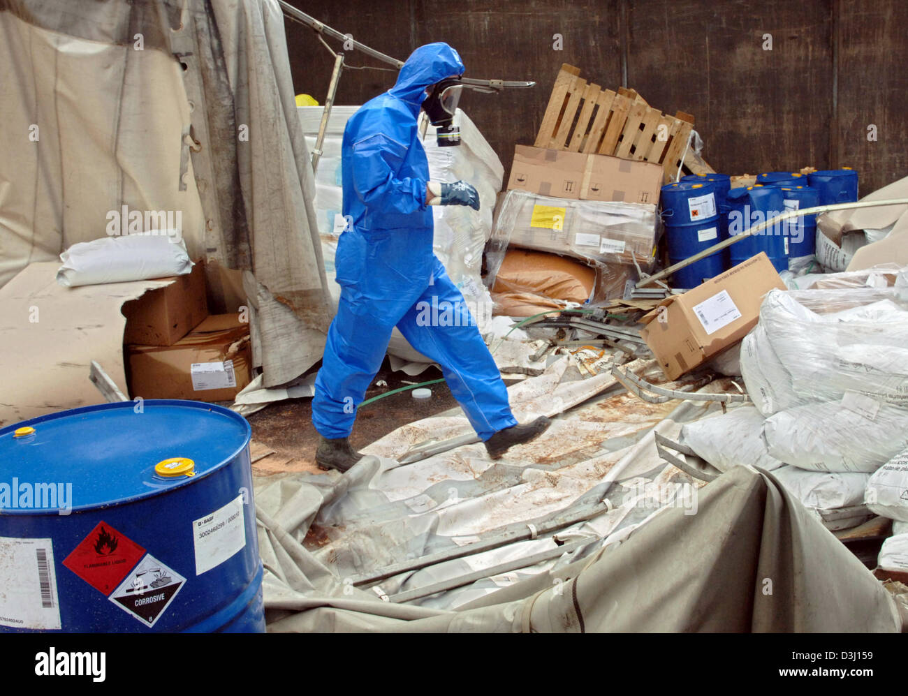 (dpa) - A fireman in protective blue clothing and mask salvages poisonous chemicals from a lorry which was involved in an accident on the A45 motorway near Wetzlar, Germany, Thursday, 30 June 2005. The driver of the lorry, which was loaded with hazardous material, apparently lost control over the vehicle for reasons unknown and smashed into a crash barrier where the tractor-trailer Stock Photo