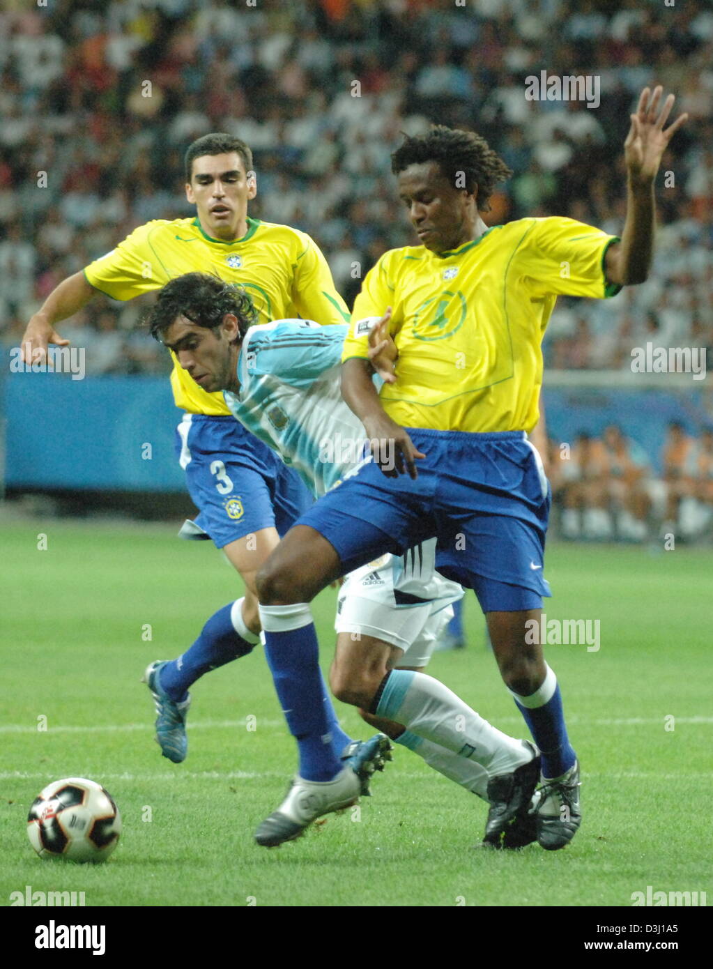 (dpa) - Brazilian soccer player Roque Junior (R) struggles for the ball with Argentinian Cesar Delgado (C)  with Brazilian Lucio looking on during the finals of the Confederations Cup tournament Brazil vs. Argentina in Frankfurt, Germany, 29 June 2005.  (Eds: Internet use and mobile applications subject to FIFA's terms and conditions) Stock Photo