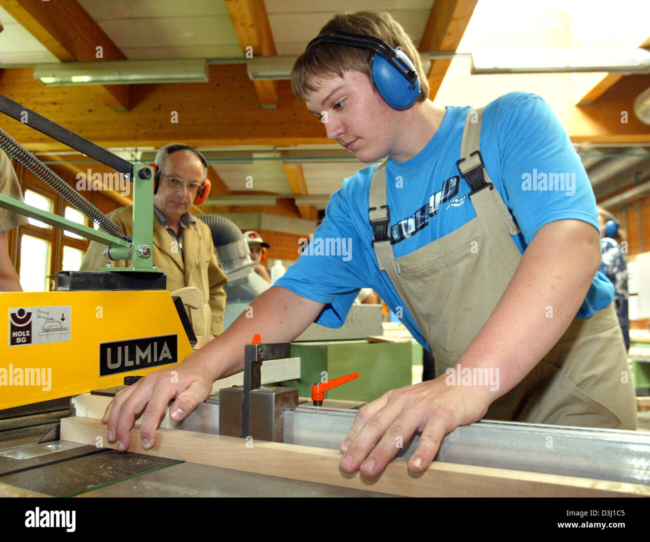 dpa) - Apprentice Florian Birk saws a piece of wood as his instructor  Konrad Paukner (L) looks