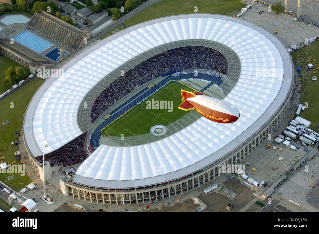 (dpa) - An airship hovers over the altered Olympic Stadium pictured at sunset shortly prior to the tingler of the 62nd DFB Cup Final in Berlin, Germany, 28 May 2005. The arena was renovated and reconstructed within four years until end of July 2004 and will host four prelimenary round matches, one quarter final and the final match at the FIFA World Championships 2006 in Germany fro Stock Photo