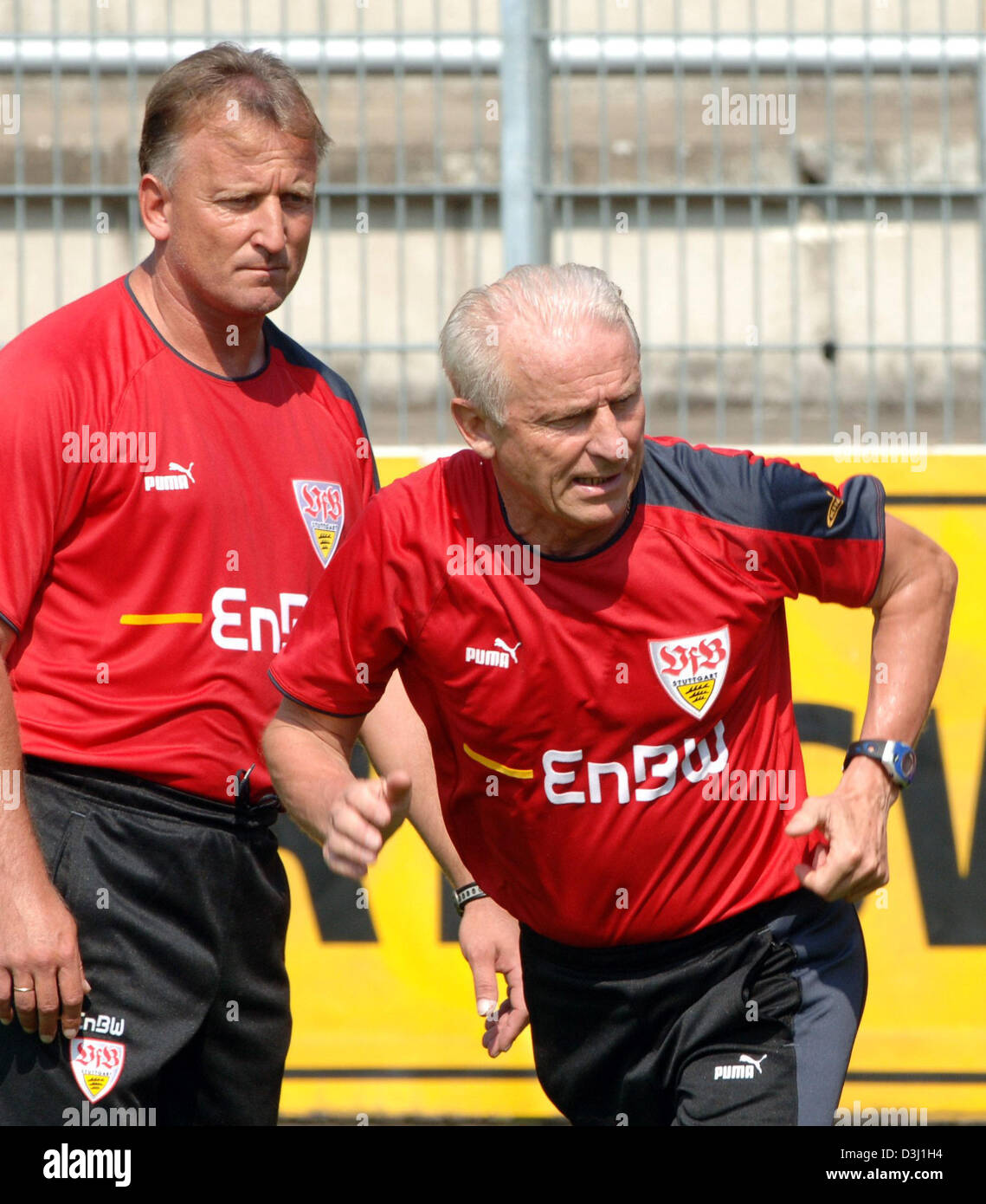 (dpa) - Head Coach of German Bundesliga club VfB Stuttgart Italian Giovanni Trapattoni (R) shows a move to his players during his first training session in Stuttgart, Germany, 27 June 2005. On Trappatoni's left side stands his Assistant Coach German soccer legend Andreas Brehme. Stock Photo