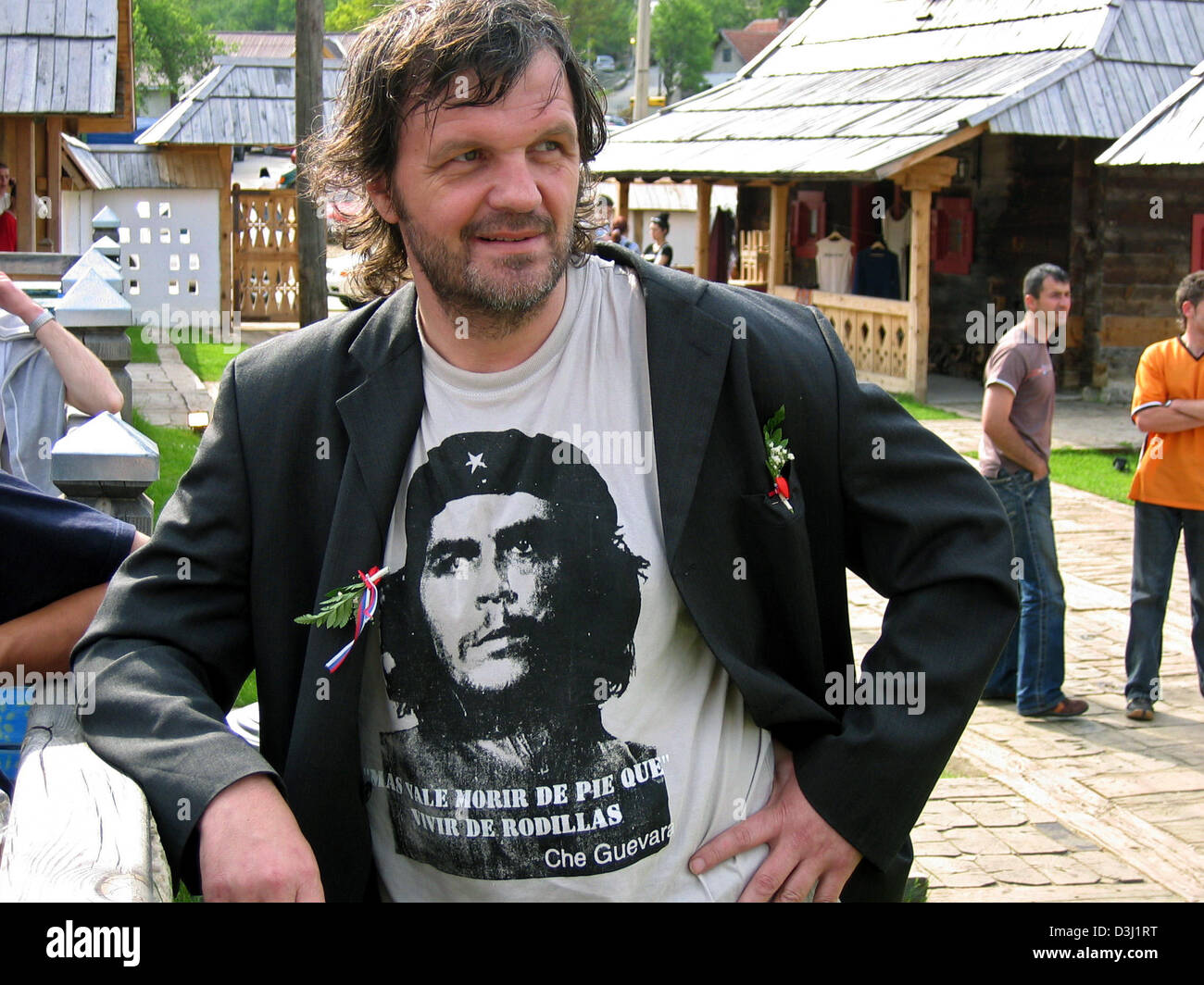 (dpa) - Bosnian film director Emir Kusturica smiles as he leans against a wooden ballustrade in his village called 'Kuestendorf', Serbia and Montenegro, 28 May 2005. Kusturica founded and built the village of 'Kuestendorf' as a centre for culture and science in the Serbian mountains. In its simplicity and humility the village is ment to represent an alternative counterdraft to a wo Stock Photo