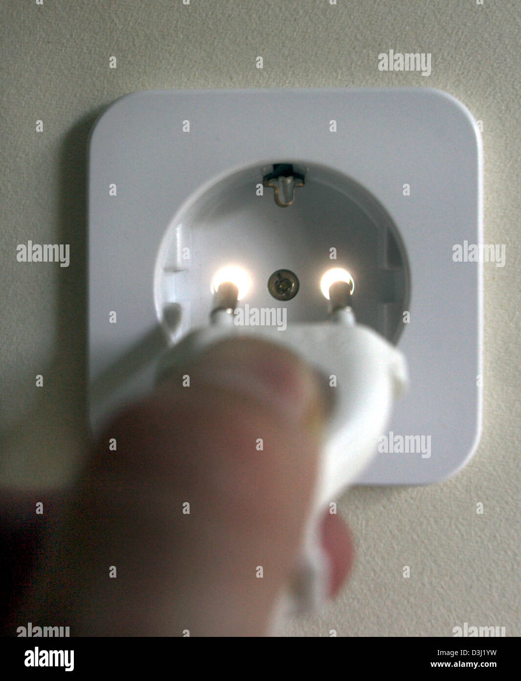 (dpa) - The picture shows a plug being put into a socket in Frankfurt ...