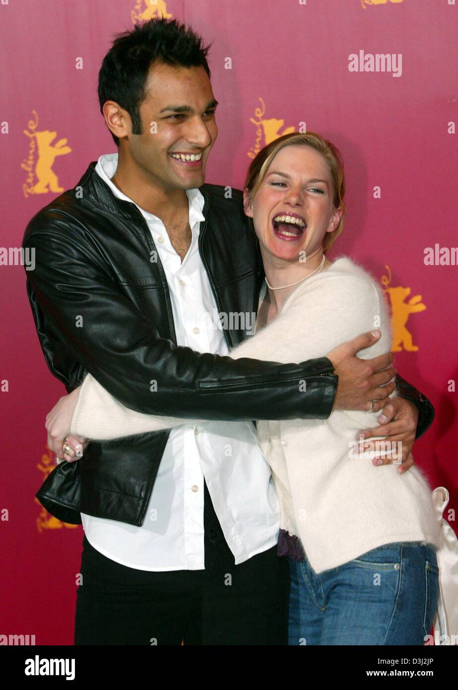 (dpa) - British actors Eva Birthistle and Atta Yaqub hug each other and smile as they attend a press conference during the 54th Berlinale International Film Festival in Berlin, 13 February 2004. Birthistle and Yaqub presented their new film 'A Fond Kiss'. The film tells the love story between a young Catholic woman from Glasgow and the son of Muslim immigrants from Pakistan. Stock Photo
