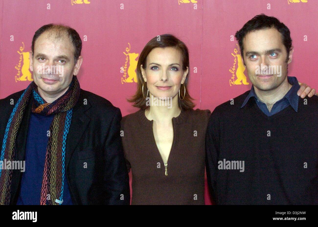 (dpa) - French film director Cedric Kahn (R) and French actors Carole Bouquet (C) and Jean-Pierre Darroussin stand next to each other and smile at a press conference during the 54th International Film Festival in Berlin, 10 February 2004. They presented their film 'Feux rouges' (rear lights) which will participate in the festival's competition for the 'Golden Bear'. The festival ru Stock Photo