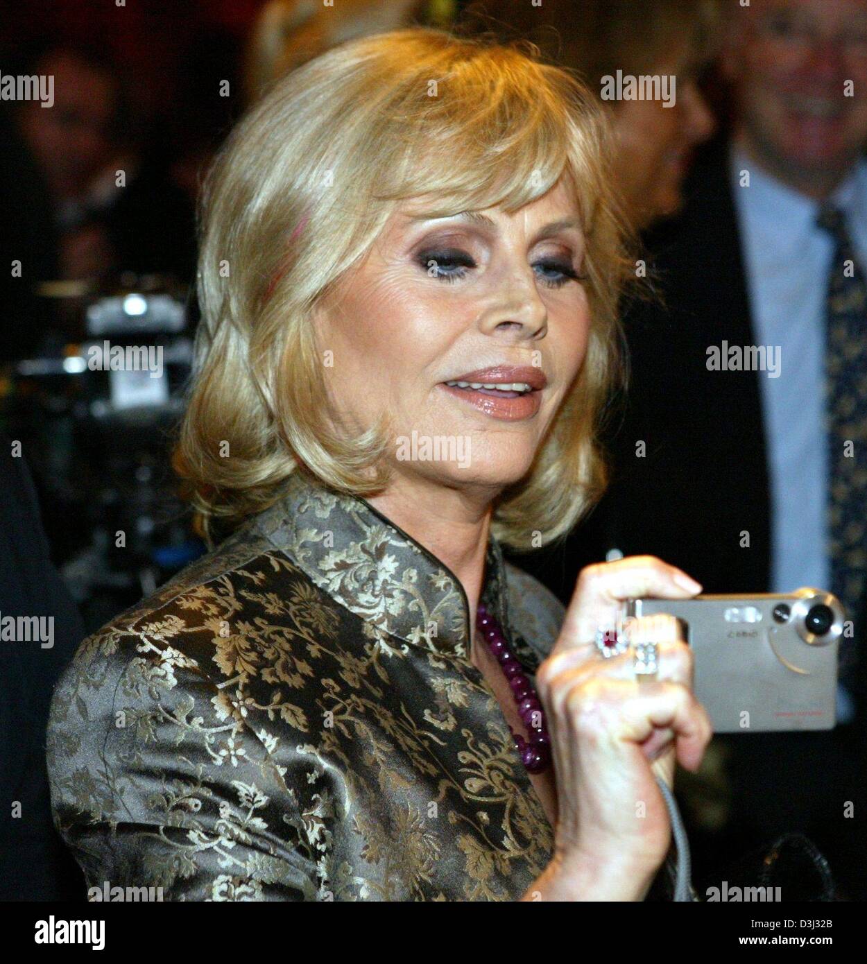 (dpa) - Swedish actress Britt Eklund, aka Britt Ekland, takes pictures as she attends the 'Lambertz Monday Night Party' in Cologne, Germany, 02 February 2004. Numerous celebrities from politics, economy, sports and show business attended the event which took place in the context of the 34th international sweets fair ISM. Stock Photo