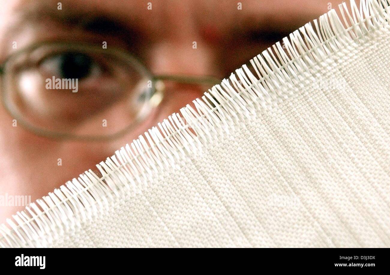 (dpa files) - Weaver Heinz Behrens shows a textile piece made of coated glass fibres at the 'P-D aitec' company in Bitterfeld, eastern Germany, 26 June 2003. The company belongs to the Preiss-Daimler group and produces a patented impregnated glass fibre textiles, which are especially durable and enduring. The textiles are equally used in the space travel industry and the production Stock Photo