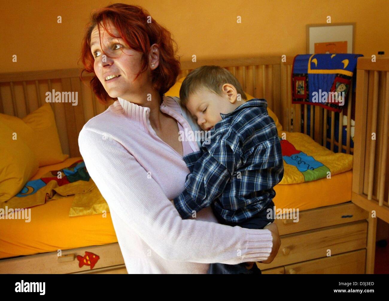 (dpa) - Bettina Zander carries her two and a half year old son Mika who is terminally ill on her arms as she stands in one of the bright children's rooms of the Lionheart hospice for children in Syke, Germany, 20 September 2003. Mika was reanimated after undergoing a surgery, and has since been in a coma vigil due to the oxygen deficiency. Stock Photo