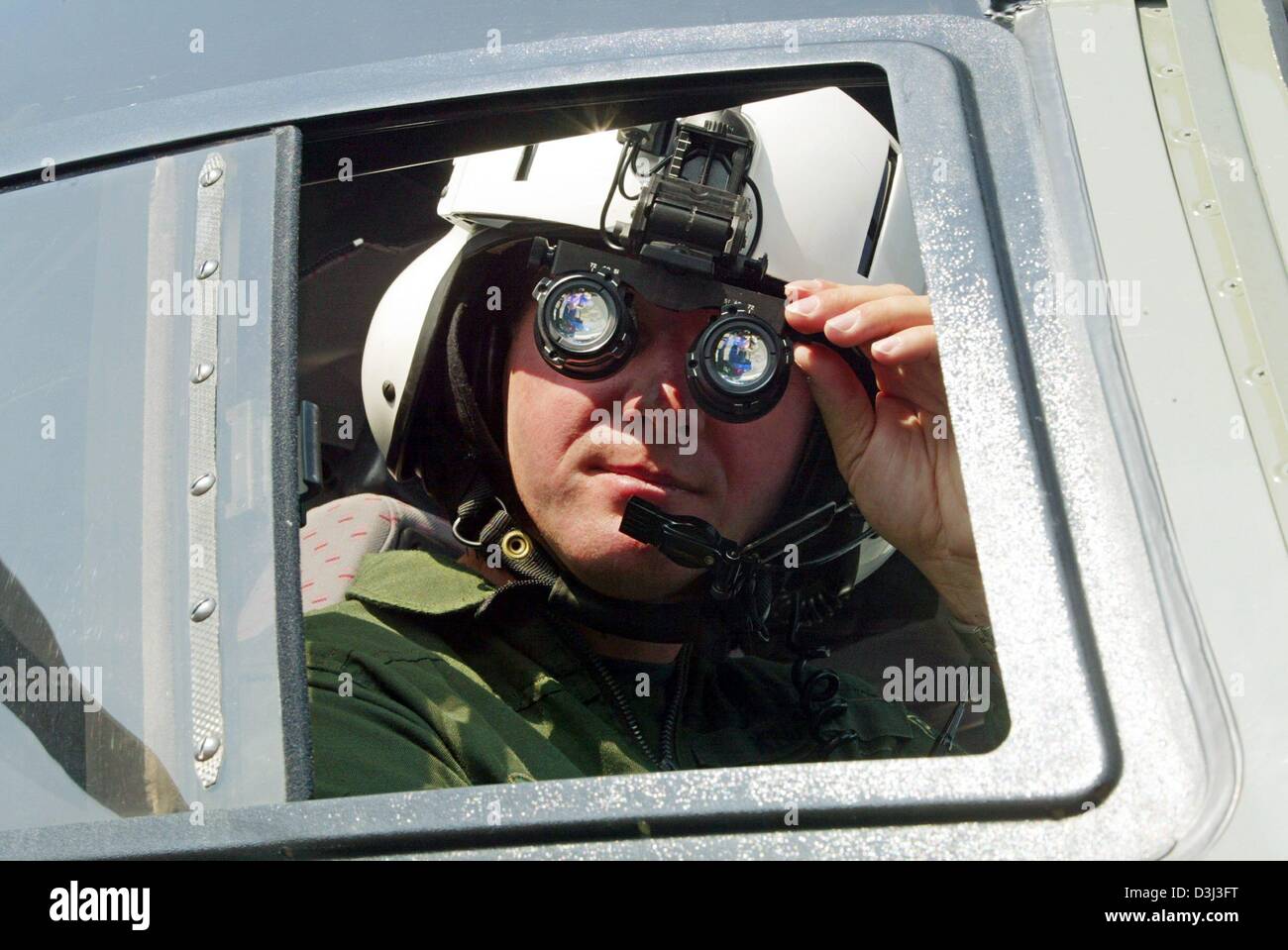 (dpa) - Police officer Thomas Knaup wears a night vision gear while sitting in a police helicopter type EC 155, at the airport in Dortmund, Germany, 3 September 2003. Stock Photo