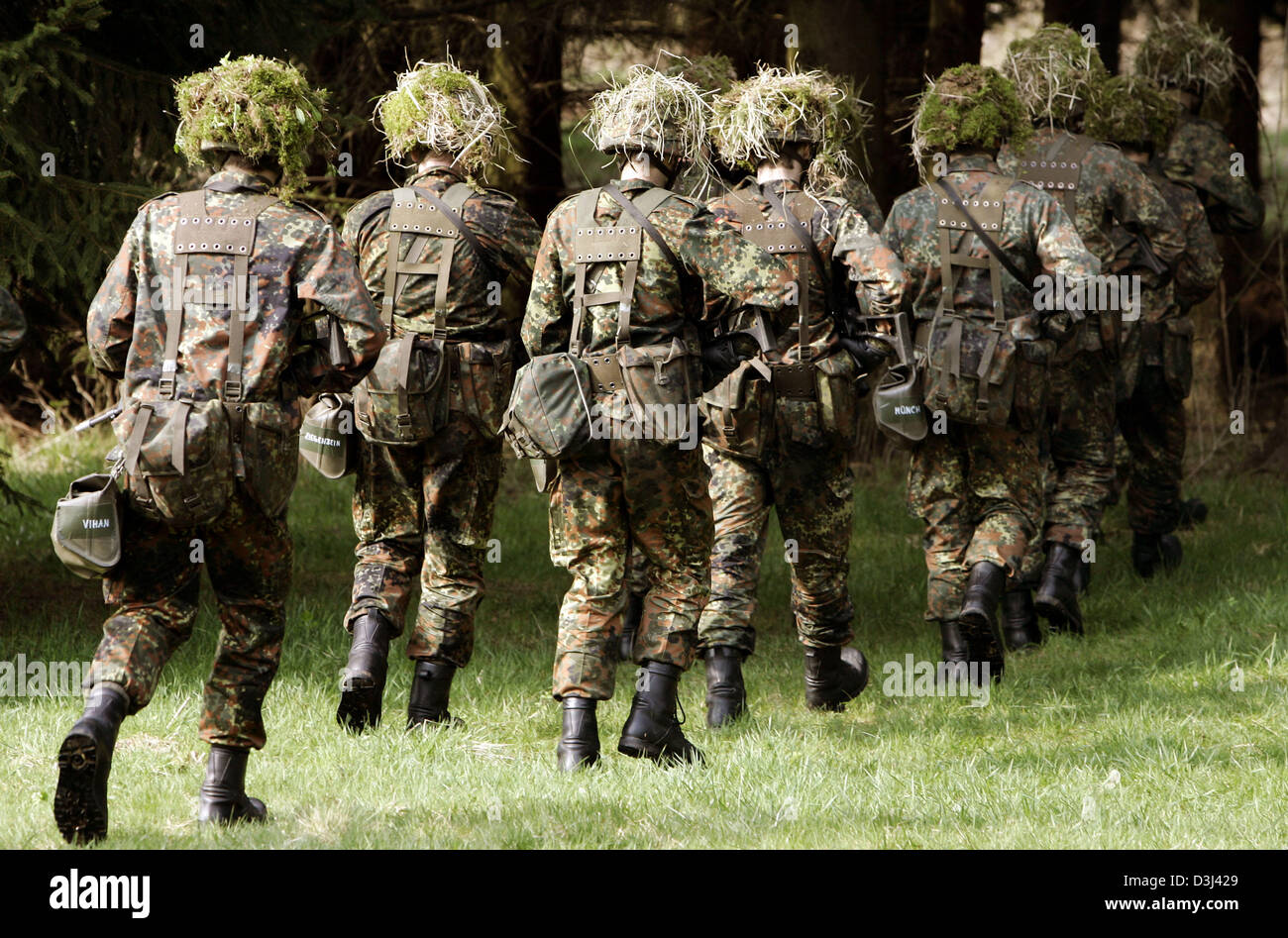 (dpa file) -  A group of conscript of the armoured infantry division of the German Bundeswehr, dressed in camouflage and armed with a G36 rifle, run in a forest during a field exercise as part of the basic military training at the Knuell Barracks in Schwarzenborn, Germany, 14 April 2005. Stock Photo