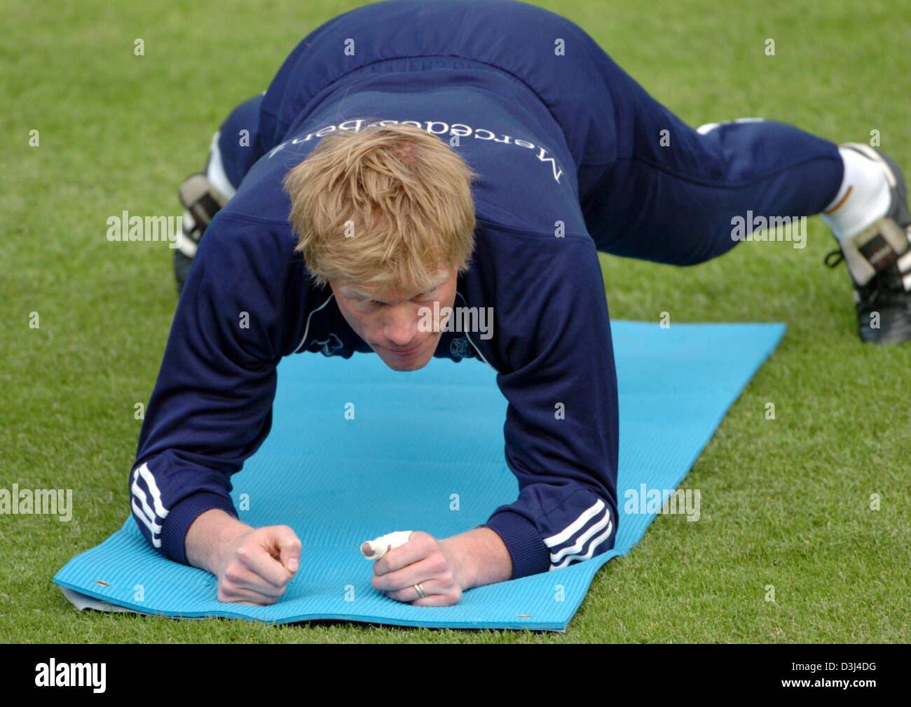 (dpa) - FC Bayern Munich's goalkeeper Oliver Kahn conducts a stretching exercise during a practice sessions of the German national soccer team at the soccer stadium in Frankfurt, Germany, Sunday, 12 June 2005. After a two-week lasting workout and a three-day vacation the soccer ball was again the centre of the team's attention. The German team prepared to play against the Australia Stock Photo