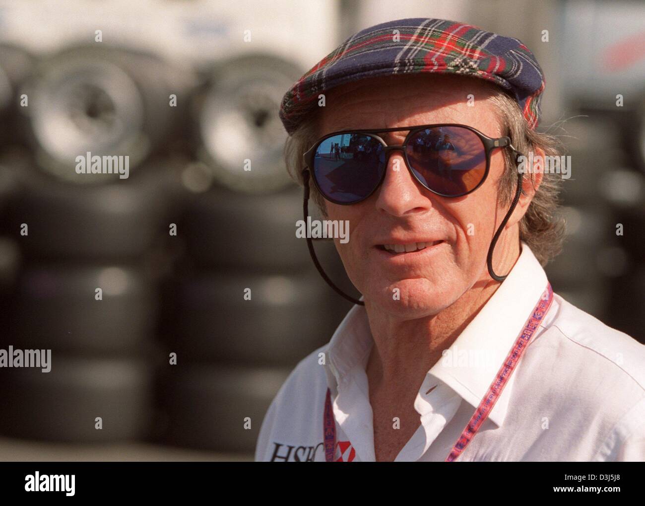(dpa files) - British racing legend Jackie Stewart smiles for the photographers at the Formula 1 race track in Magny-Cours, France, 27 June 1999. He was Formula 1's popstar, the sport's first big money maker or simply 'Jack the Hair'. Stewart is still a genuine idol and nobody can imagine Formula 1 without him. The three time world champion is still in business. As a representant f Stock Photo