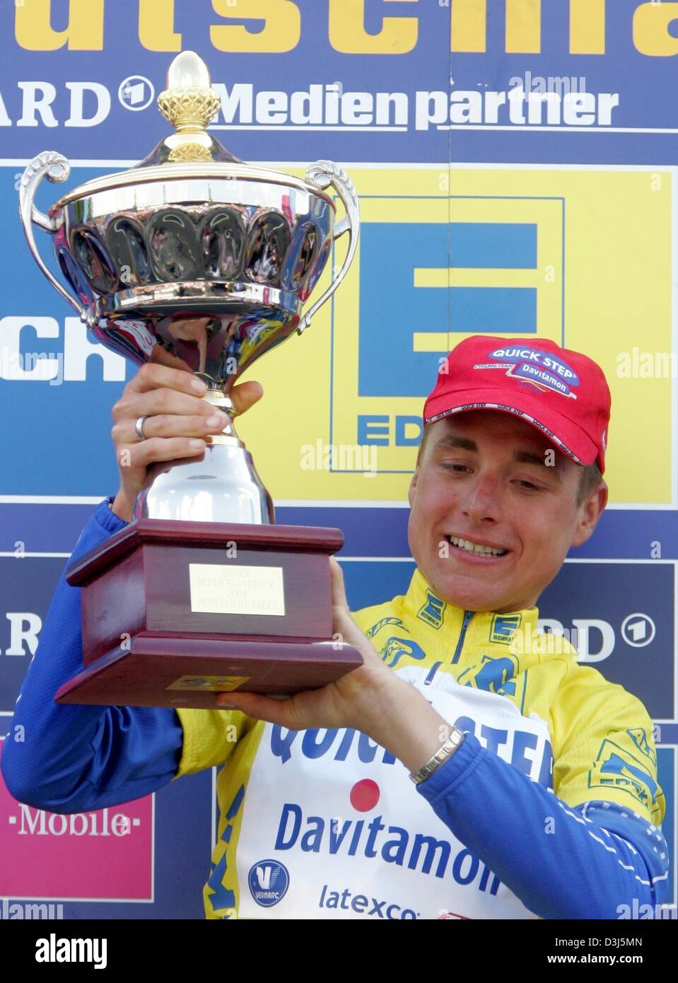 (dpa) - The 23-year old cycling pro Patrik Sinkewitz of Team Quick-Step Davitamon smiles and poses with his trophy after winning the Tour of Germany cycling race in Leipzig, Germany, 6 June 2004, which marks his biggest victory as yet. Stock Photo