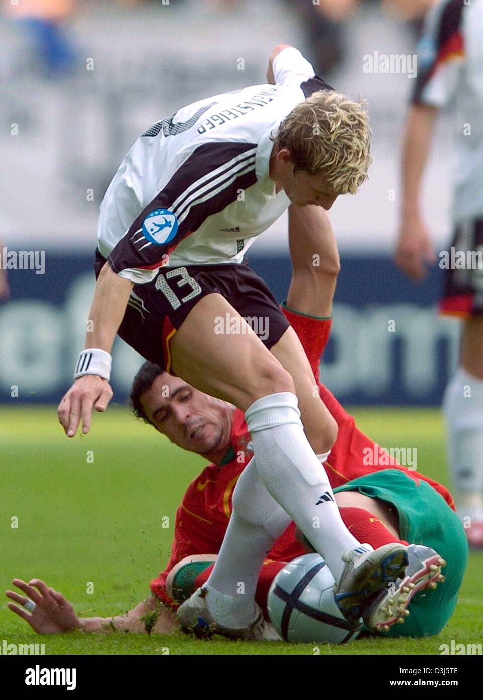 (dpa) - Germany's Bastian Schweinsteiger (front) fights for the ball with Portugal's Hugo Almeida. The Portuguese under 21 national soccer team beat the German under 21 squad with a score of 2-1 at the Bruchweg stadium in Mainz, Germany, 2 June 2004. With the victory Portugal moves into the next round of the under 21 European Championship while host Germany is eliminated. Stock Photo