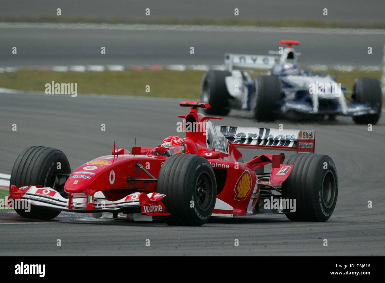 (dpa) - German Formula 1 champion Michael Schumacher (team Ferrari) drives in front of his Columbian rival Juan Pablo Montoya (team BMW-Williams) during the European Grand Prix at the Nuerburgring in Germany, 30 May 2004. Schumacher went on to win the race. Stock Photo